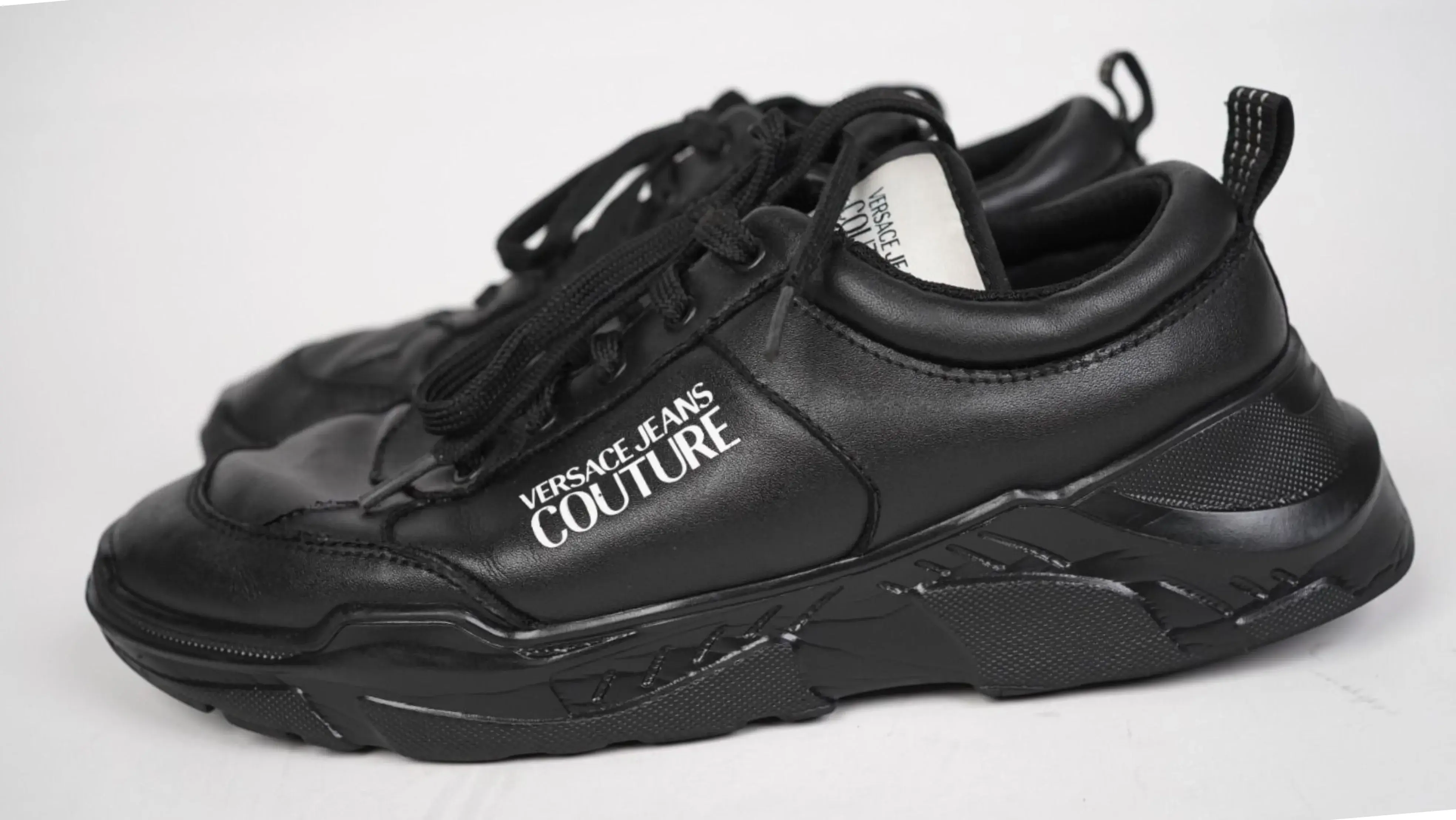 Before Versace shoes restoration damaged PU surface with faded tone and dirt accumulation